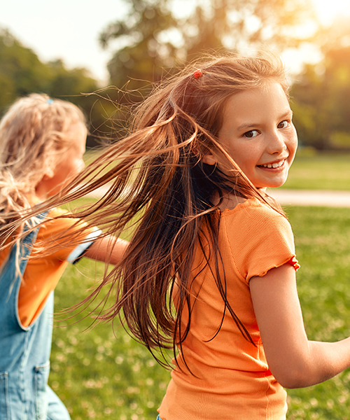 two girls running in field